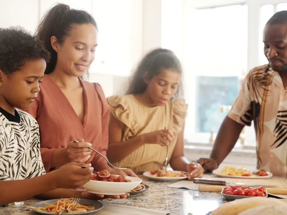A family eating together at one table, each person with their own plate.